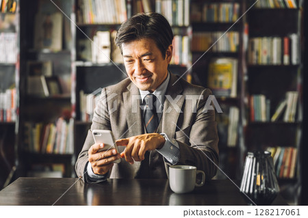亞洲男性商人在圖書館使用智慧型手機學習(電子書、閱讀、文學、文化、復古) 亞洲男性商人在圖書館使用智慧型手機學習(電子書、閱讀、文學、文化、復古) 128217061