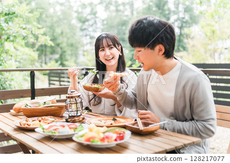 Couples and married couples dining on a wooden deck, terrace, or balcony (glamping/verandaping) Couples and married couples dining on a wooden deck, terrace, or balcony (glamping/verandaping) 128217077