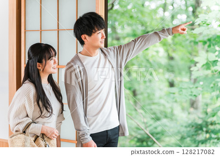 A couple staying at a hot spring inn and Japanese-style room on a domestic trip and looking at the garden view 128217082