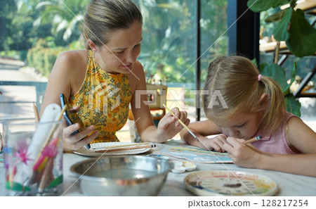 A young mother and her daughter enjoy a creative art session at home  128217254