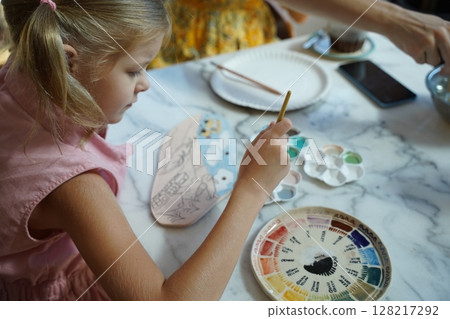 A young mother and her daughter enjoy a creative art session at home  128217292