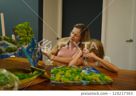 A mother and her daughter craft vibrant natural landscapes  128217363