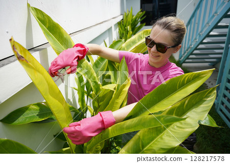 A young woman trims her beautiful garden  128217578