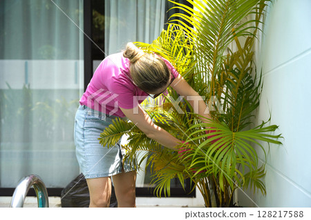 A young woman trims her beautiful garden  128217588