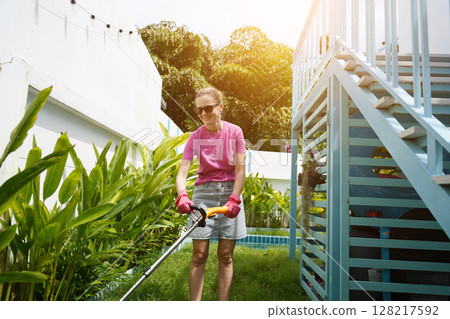 A young woman trims her beautiful garden  128217592
