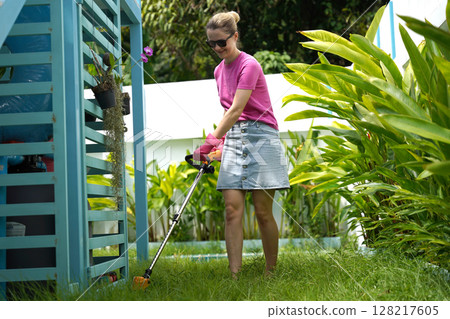 A young woman trims her beautiful garden  128217605