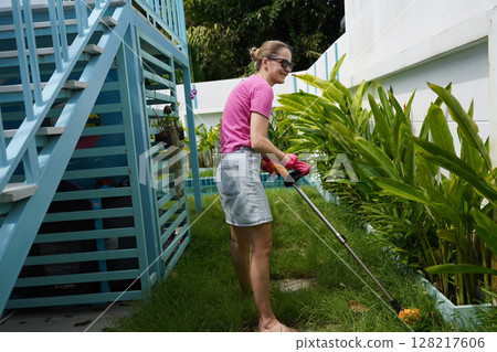 A young woman trims her beautiful garden A young woman trims her beautiful garden 128217606