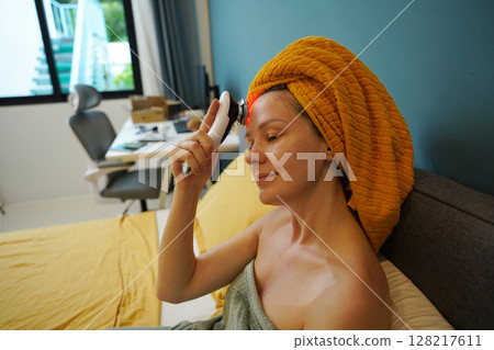 Young woman using infrared massager Young woman using infrared massager 128217611