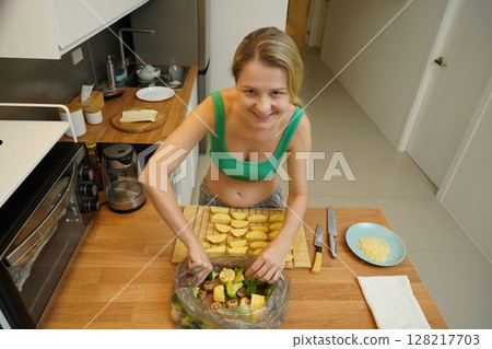 A young woman joyfully prepares a variety of healthy meals  128217703