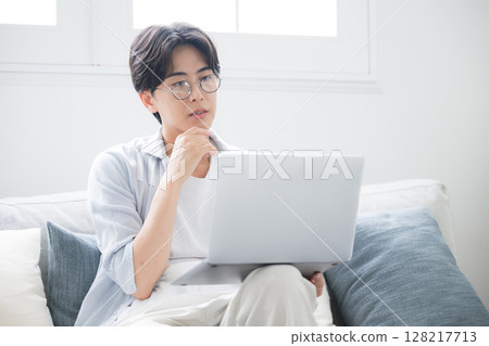 A man thinking while looking at a computer. He is troubled and worried. A man thinking while looking at a computer. He is troubled and worried. 128217713