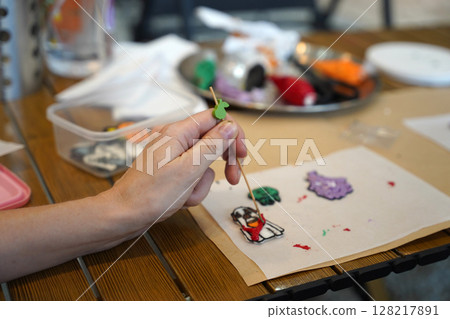 Mother and her daughter paint Halloween cookies  128217891