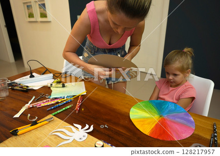 A mother and her young daughter engage in a colorful painting activity A mother and her young daughter engage in a colorful painting activity 128217957