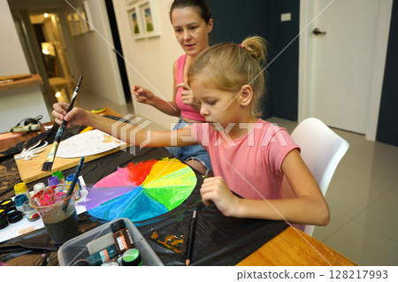 A mother and her young daughter engage in a colorful painting activity A mother and her young daughter engage in a colorful painting activity 128217993