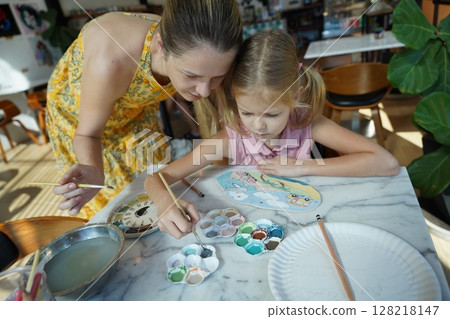 A young mother and her daughter enjoy a creative art session at home  128218147