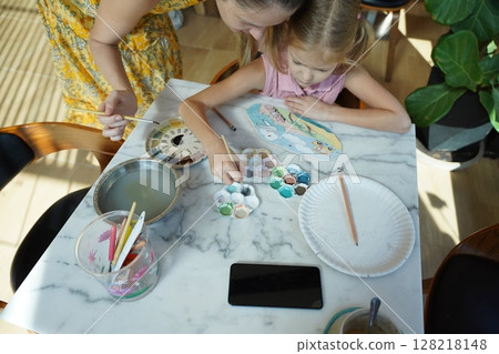 A young mother and her daughter enjoy a creative art session at home  128218148