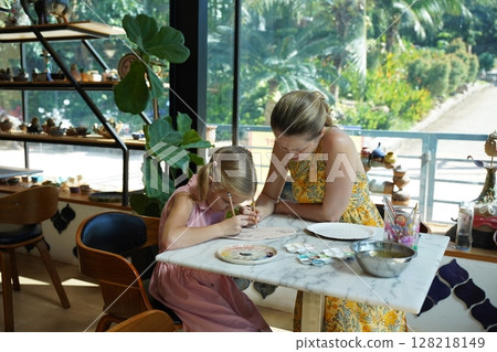 A young mother and her daughter enjoy a creative art session at home  128218149