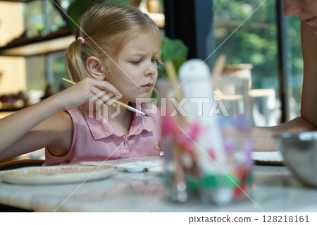 A young mother and her daughter enjoy a creative art session at home  128218161