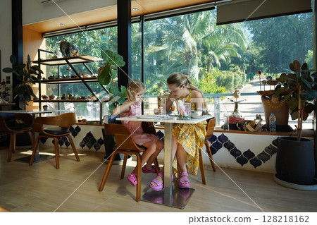 A young mother and her daughter enjoy a creative art session at home  128218162