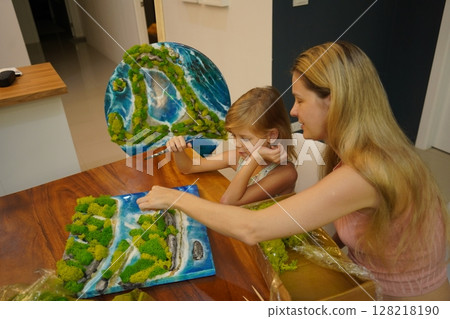 A mother and her daughter craft vibrant natural landscapes  128218190