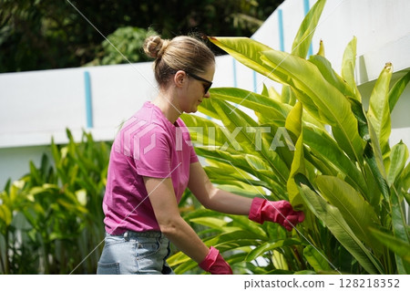 A young woman trims her beautiful garden A young woman trims her beautiful garden 128218352