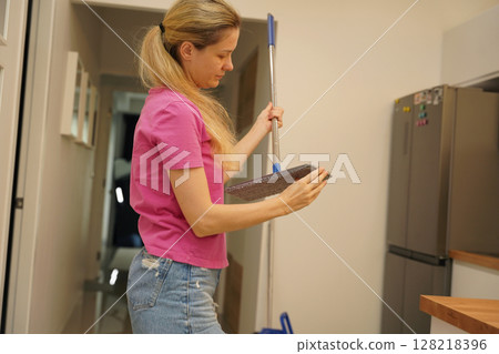 A woman is cleaning her living room at home A woman is cleaning her living room at home 128218396