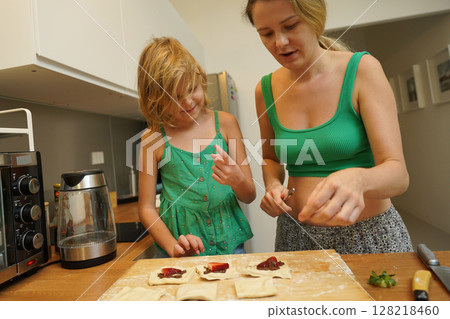 Cooking moments together with mother and daughter at the kitchen 128218460
