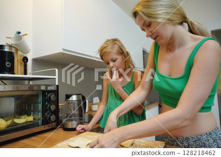 Cooking moments together with mother and daughter at the kitchen 128218462