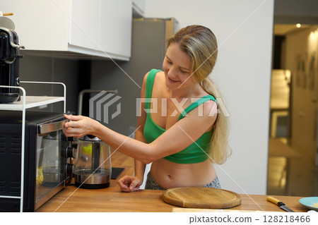 A young woman joyfully prepares a variety of healthy meals  128218466