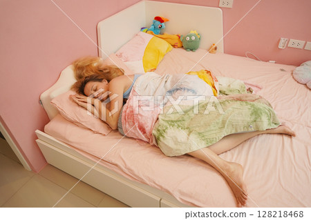 A young woman is enjoying a wonderfully serene morning in her bedroomnd A young woman is enjoying a wonderfully serene morning in her bedroomnd 128218468