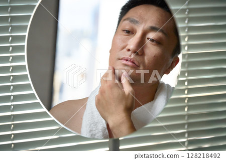 一名男子正在檢查自己的皮膚狀況 128218492