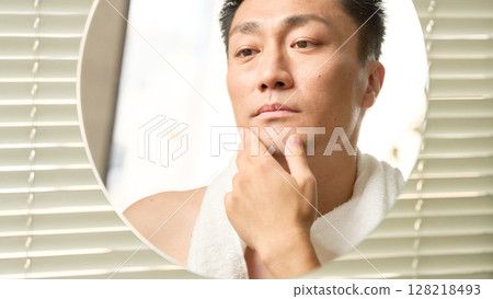 一名中年男子摸著下巴，表情嚴肅 128218493