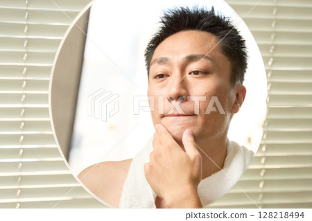 一名男子正在檢查自己的皮膚狀況 128218494