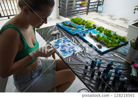 The process of making the art decor of epoxy resin, natural stones and moss 128218501