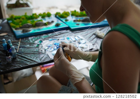 The process of making the art decor of epoxy resin, natural stones and moss 128218502