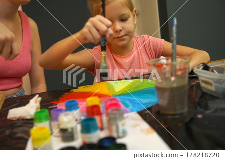 A mother and her young daughter engage in a colorful painting activity A mother and her young daughter engage in a colorful painting activity 128218720