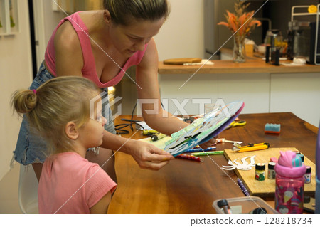 A mother and her young daughter engage in a colorful painting activity A mother and her young daughter engage in a colorful painting activity 128218734