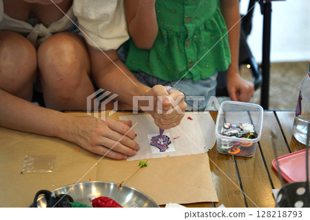 Mother and her daughter paint Halloween cookies  128218793