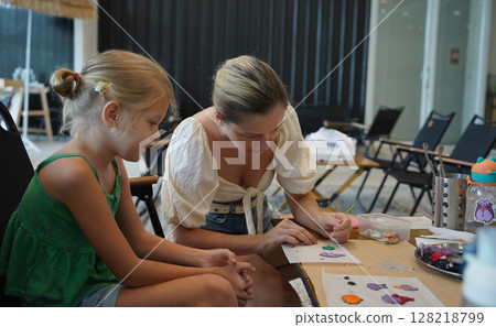 Mother and her daughter paint Halloween cookies Mother and her daughter paint Halloween cookies 128218799