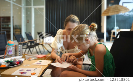 Mother and her daughter paint Halloween cookies Mother and her daughter paint Halloween cookies 128218801