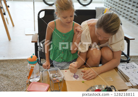 Mother and her daughter paint Halloween cookies Mother and her daughter paint Halloween cookies 128218811