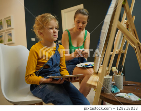 Teacher in workshop teched two girls how to assemble a thermo mosaic Teacher in workshop teched two girls how to assemble a thermo mosaic 128218818