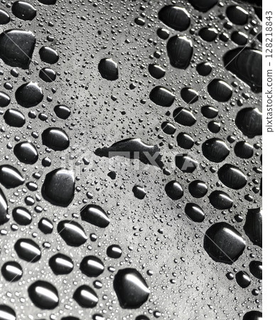 A detailed closeup view showcasing water droplets on a blue surface 128218843