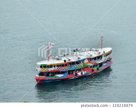 A colorful boat floats gently in the water with a flag on the mast A colorful boat floats gently in the water with a flag on the mast 128218874
