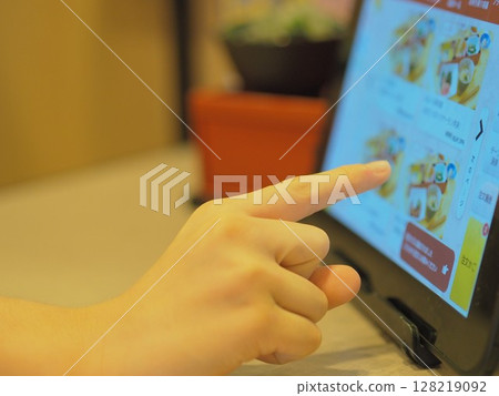 Child's hand ordering on a touch panel (at a restaurant) Child's hand ordering on a touch panel (at a restaurant) 128219092
