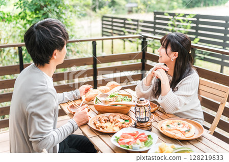 Couples and married couples dining on a wooden deck, terrace, or balcony (glamping/verandaping) 128219833