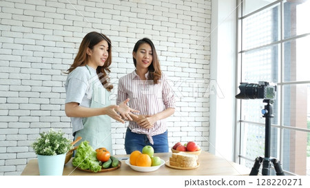 Asian influencer vlogger live review tomato skin care healthy eating lifestyle. Two Young Women Friends blogger vlog Happy Lifestyle vitamin C tomato vegetable fruit. Vlog Two women talk social media 128220271