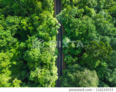Aerial view of road in green forest and transportation. Nature conservation environment. Aerial view of road in green forest and transportation. Nature conservation environment. 128220533