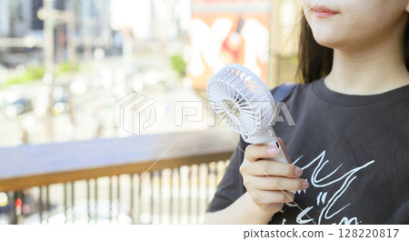 A woman who uses a handy fan 128220817