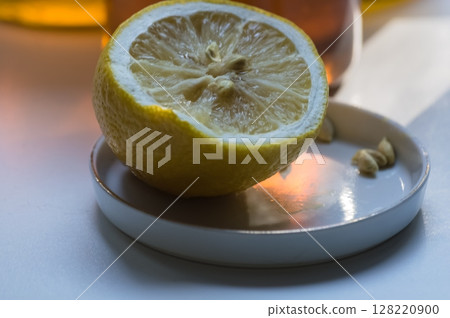 Lemon on a plate with a glass of lemonade in the background 128220900