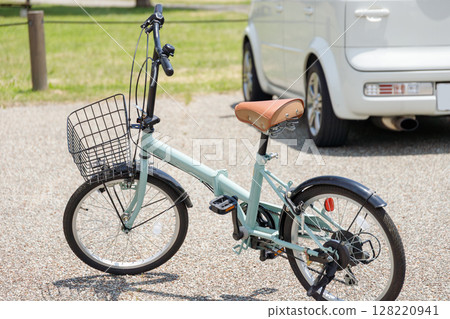 Folding bike on the background of parking lot and cars in the park Folding bike on the background of parking lot and cars in the park 128220941